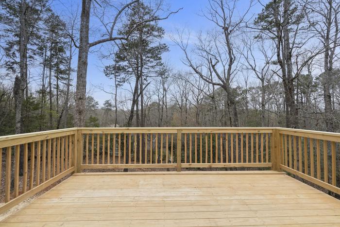 New wood deck overlooking the woods at the Lakeside Getaway home