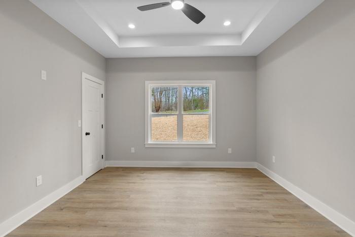 Bedroom with a tray ceiling and ceiling fan at the Lakeside Getaway home