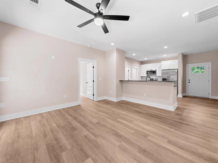 Living room open to the kitchen with a ceiling fan