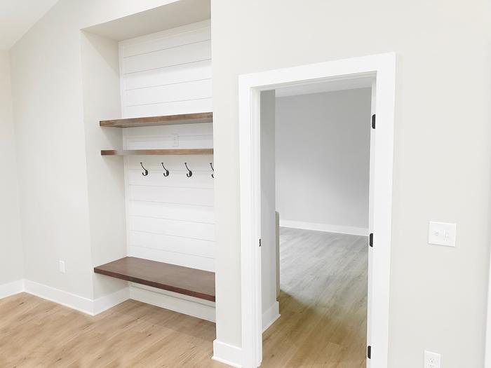 Mudroom drop zone with shiplap, a bench and coat hooks