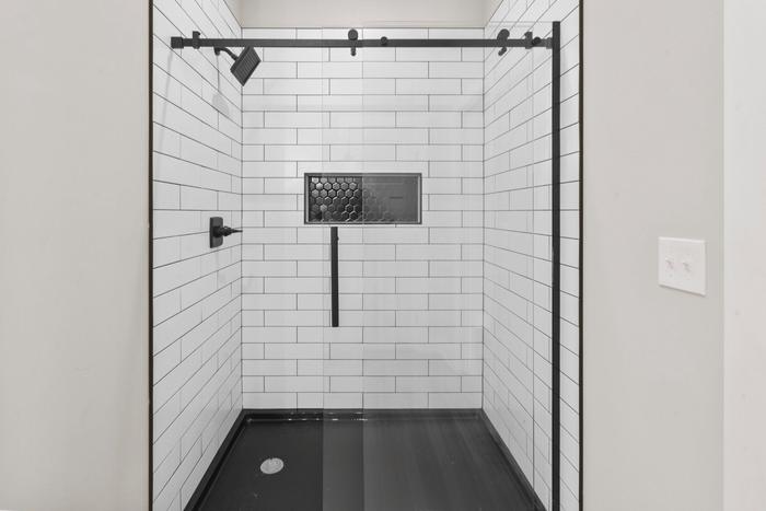 Walk-in shower with white subway tile and black fixtures