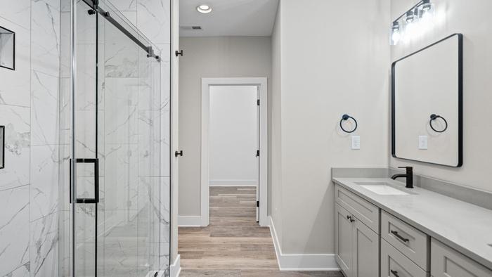 Bathroom with a marble-look glass shower and gray vanity at Raven's Ridge
